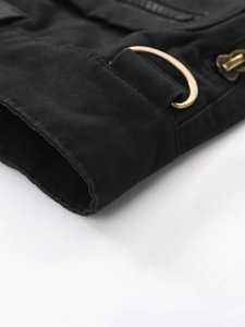 Macro detail of black cargo pants featuring durable twill fabric and golden D-ring hardware