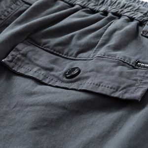 Detail of cargo pants elastic waist and charcoal gray side pocket with button
