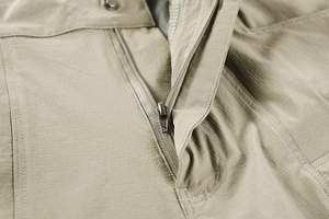 Macro shot of durable khaki tactical pants with a quality metal zipper and reinforced button