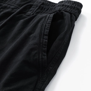 Close-up of elastic drawstring waistband and side pockets on black cargo pants