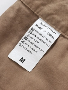Detailed macro view of the 100% cotton fabric texture and washing label for cargo pants