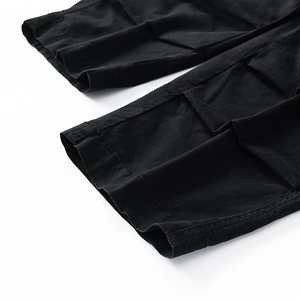 Detail of double-stitched hem on black cargo pants with durable cotton twill texture