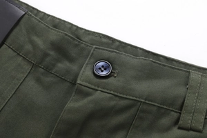 Detail shot of army green cotton cargo pants showing belt loops and blue resin button