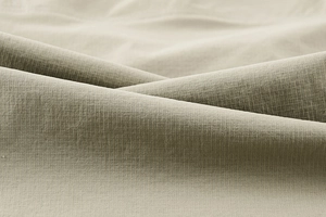 Macro view of khaki stretch tactical pants showing woven ripstop fabric texture and grain