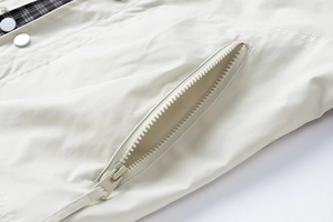 Detail of jacket side pocket with zipper closure and classic plaid lining texture