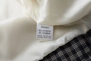 Detail of plaid jacket showing 100% polyester lining and inner washing label