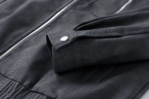 Macro-opname van herenleren jas met slangenhuidtextuur en metalen ritssluiting detail
