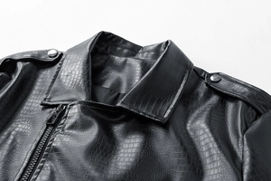 Close-up of black crocodile embossed faux leather jacket with lapel and shoulder straps
