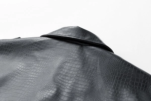 Close-up of black faux leather jacket featuring premium crocodile embossed texture detail