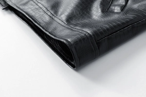 Close-up of crocodile embossed black leather jacket showing precise double stitching detail