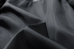 Detailed view of the smooth, high-density black synthetic fabric texture with subtle luster
