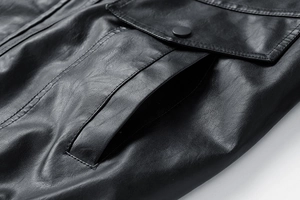 Detail view of the black leather jacket showing pockets and premium stitching texture