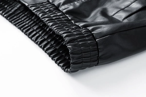 Detailed close-up of elastic ribbed hem on a premium black PU leather jacket for men