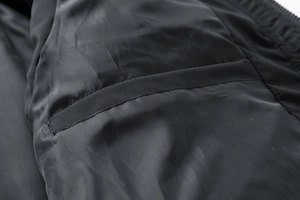 Dettaglio della tasca interna e delle cuciture precise su un gilet nero da uomo