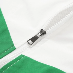 Close-up of white resin zipper with silver metal pull on green contrast casual jacket