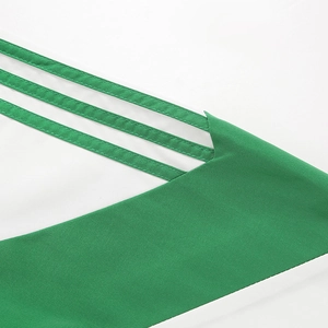 Detailed view of green twill fabric and white contrast panels with parallel decorative ribbons