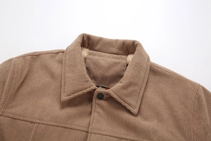 Detail eines warmbraunen Cordjacken-Kragens mit weichem Fleece-Futter und Knopf
