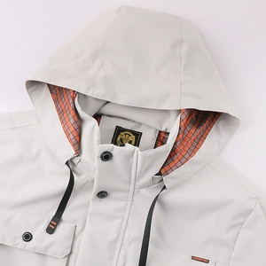 Détails d'une veste à capuche grise avec doublure à carreaux orange et boutons pression