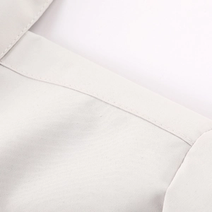 Gros plan des coutures précises et du tissu texturé gris clair d'une veste à capuche