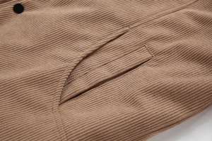 Detail einer braunen Cordjacke mit vertikaler Rippstruktur und schräger Leistentasche