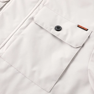 Gros plan sur poche à rabat avec étiquette logo orange sur veste décontractée grise