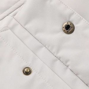 Détail des boutons-pression en métal bronzé avec motif d'étoile sur tissu gris clair