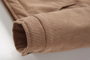 Detailaufnahme der hellbraunen Cordjacke mit gerippter Textur und feiner Naht an der Manschette