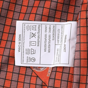 Gros plan sur l'étiquette d'entretien montrant la composition du tissu 100 % polyester de la veste