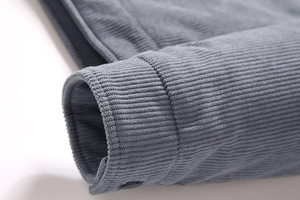 Detalle del puño de una chaqueta de pana con botón a juego en tono gris azulado