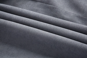 Primer plano de tela de pana gris que muestra la textura gruesa y los detalles premium