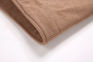 Detailaufnahme der braunen gerippten Cord-Manschette und der schweren Vlies-Textur