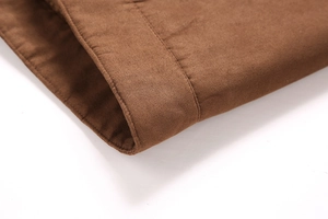 Gros plan détaillé des coutures premium sur l'ourlet et le poignet de la veste marron