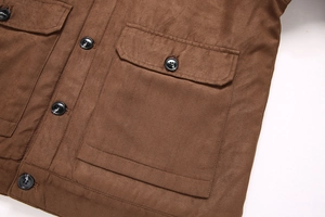 Détail d'une veste en daim marron montrant la texture mate et la poche à rabat boutonnée