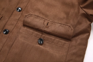 Détail de la poche de veste en daim marron foncé avec bouton à motif marbré