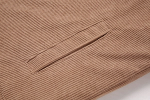 Makroaufnahme der braunen Kordstruktur und der sauberen Paspeltasche auf der Jacke