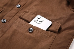 Détail de la poche de veste en daim marron avec rabat et bouton montrant la capacité
