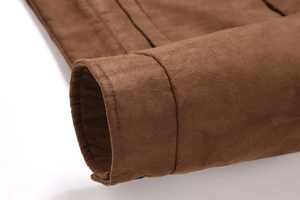 Vue détaillée de la texture du daim et des surpiqûres sur le poignet de la veste homme