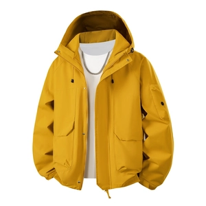 Detail of yellow outdoor jacket showing windproof fabric, cargo pockets, and hood drawstring