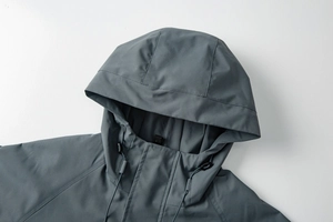 Close-up of adjustable drawstring hood and collar details on dark grey outdoor jacket