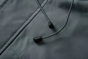 Macro detail of high-density windproof jacket fabric with reinforced stitching and drawstring toggle