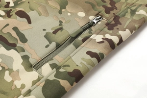Close-up of camouflage outdoor jacket featuring reinforced seams and hidden zipper pocket detail