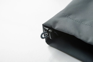 Detail of windproof outdoor jacket hem with adjustable elastic drawstring and toggle