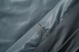 Detailed close-up of premium windproof fabric, durable zippers and precise double stitching