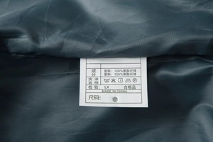 Detail view of the inner care label showing 100% polyester fabric and washing icons