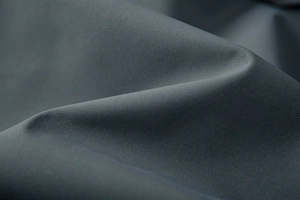 Macro texture of dark charcoal gray windproof jacket fabric with high-density weaving detail