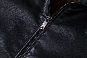Detail van zwart leren jack met zilveren rits en dikke bruine voering van imitatiebont