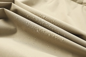 Dettaglio macro del tessuto impermeabile kaki con gocce d'acqua sulla giacca con cappuccio