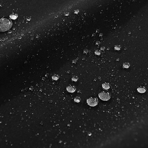 Macro-opname van waterdichte zwarte synthetische stof met waterdruppels voor softshell jas