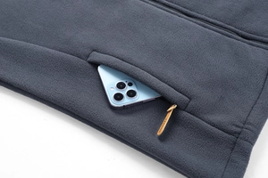 Dettaglio della giacca in pile grigio scuro con tasca a zip e tirante alla moda unico