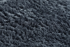 Texture macro del tessuto in pile grigio scuro che mostra fibre morbide e dense